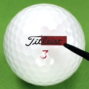 Steady Swing golf aid thin film lens held above a golf ball.